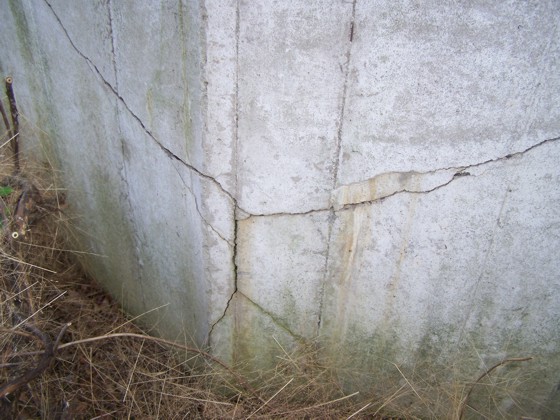  These are severe cracks in a poured concrete retaining wall. There are ways to stabilize the wall without tearing it down and starting over. Photo Credit: John Oliveras
