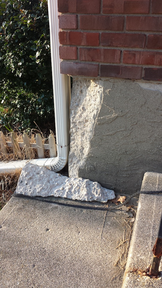 This chunk of concrete came off because the brick and mortar and poured concrete expand and contract at different rates. Photo credit: Robyn