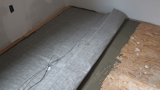 This fabric mat contains a continuous heat coil that uses frugal amounts of electricity to heat a room. © 2013 Tim Carter