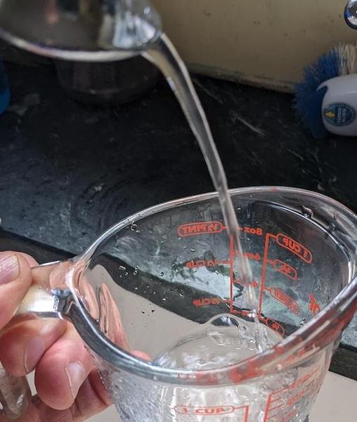 filling a measuring cup with water